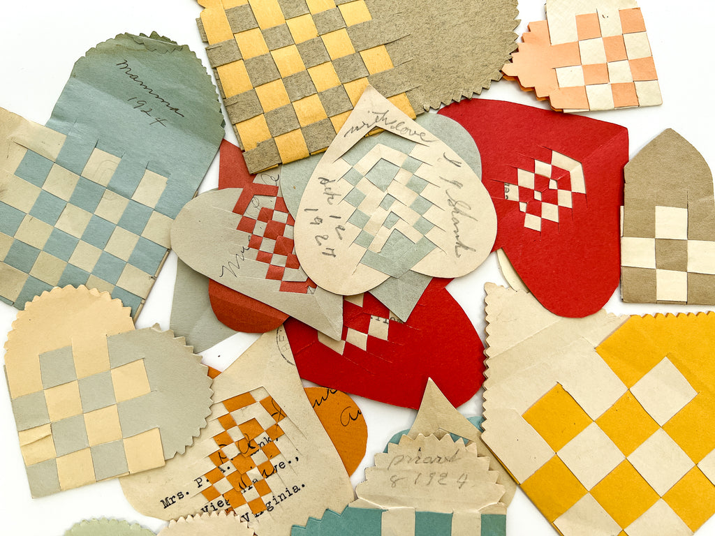 Collection of 22 woven paper pockets and heart-in-hand love tokens