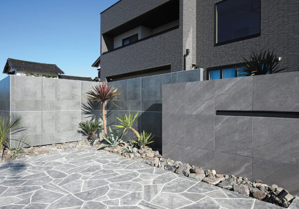 門まわりに、天然石調の落ち着いた印象のアヴェルサ タイルを使用